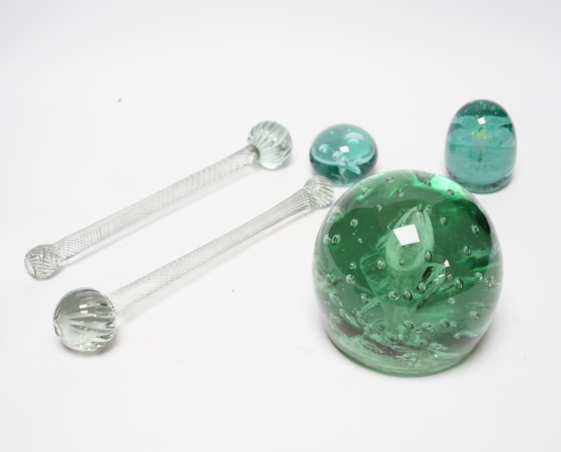 Three 19th century green glass Stourbridge dumps, one large, 12cm diam. and two small, 6cm diam., together with two glass batons, 25cm long